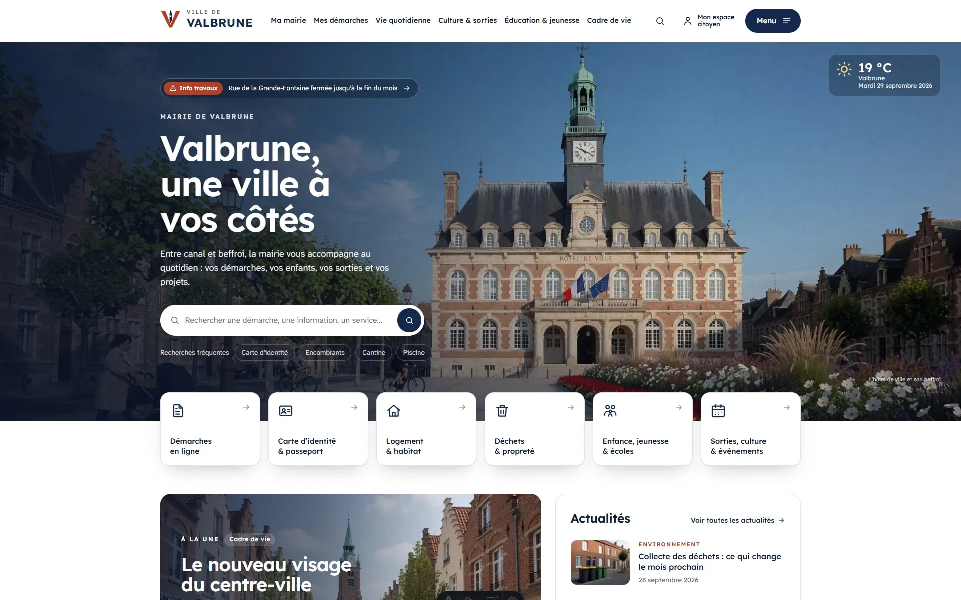 Page d’accueil de la Ville de Valbrune : l’hôtel de ville en brique et son beffroi, le titre « Valbrune, une ville à vos côtés » et une barre de recherche.